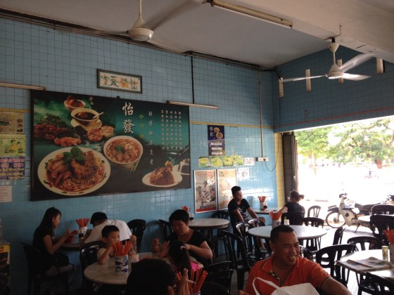 thinning lunch crowd with noodle ads on the wall..