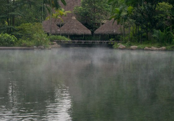 thatched villas fringe the lake and you can see the stream rising off the water